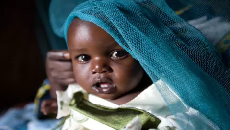Child under cover of a life saving unicef bed net