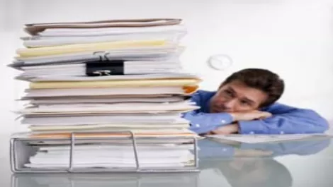 Mscamanlookingatpileofpaper